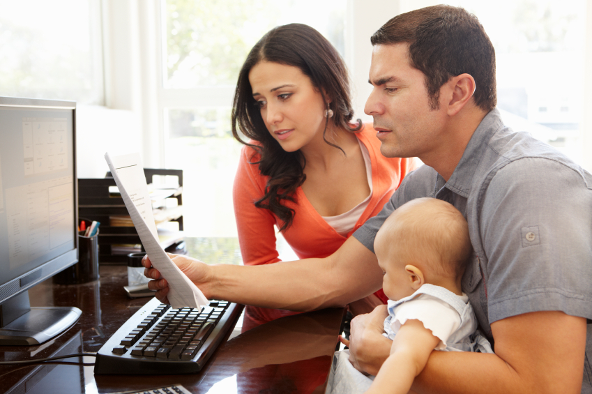 Hispanic couple and baby in home office